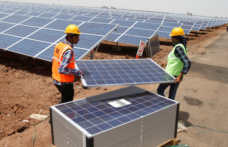 FILE PHOTO: Workers carry photovoltaic solar panels for installation at the Gujarat solar park under construction in Charanka village FILE PHOTO: Workers carry photovoltaic solar panels for installation at the Gujarat solar park under construction in Charanka village in Patan district of the western Indian state of Gujarat, April 14, 2012. REUTERS/Amit Dave/File Photo